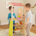 Duży drewniany stragan dla dzieci sklep: chłopcy bawią się terminalem, wagą, owocami i warzywami, ucząc się odgrywania ról.