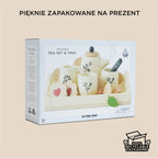 Drewniany zestaw do herbaty dla dzieci w brytyjskim stylu, pięknie zapakowany na prezent. Widoczne filiżanki, imbryk i akcesoria kuchenne w złamanej bieli z uroczymi motywami roślinnymi. Opakowanie ekologiczne.