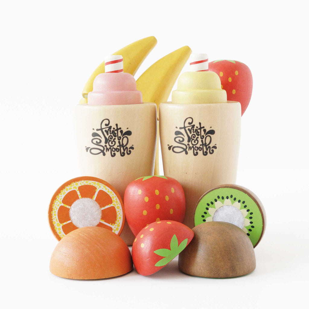 Drewniany zestaw Fruit & Smooth: dwa kubki ze smoothie, banany i pokrojone owoce – truskawka, kiwi, pomarańcza. Idealny do zabawy w zdrową kuchnię.