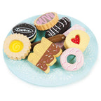 Drewniane ciasteczka zestaw: różnorodne, apetyczne ciastka i pączki w pastelowych kolorach na talerzu z ażurowym wzorem, idealne do zabawy dla dzieci.