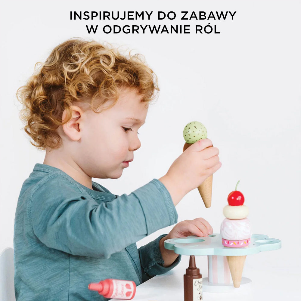 Małe dziecko bawi się drewnianymi lodami rożkami Carlo's Gelato – zestawem zabawka do kreatywnej lodziarni i odgrywania ról.
