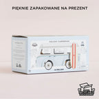 Drewniany kamper retro z deską surfingową w eleganckim, ekologicznym opakowaniu prezentowym.