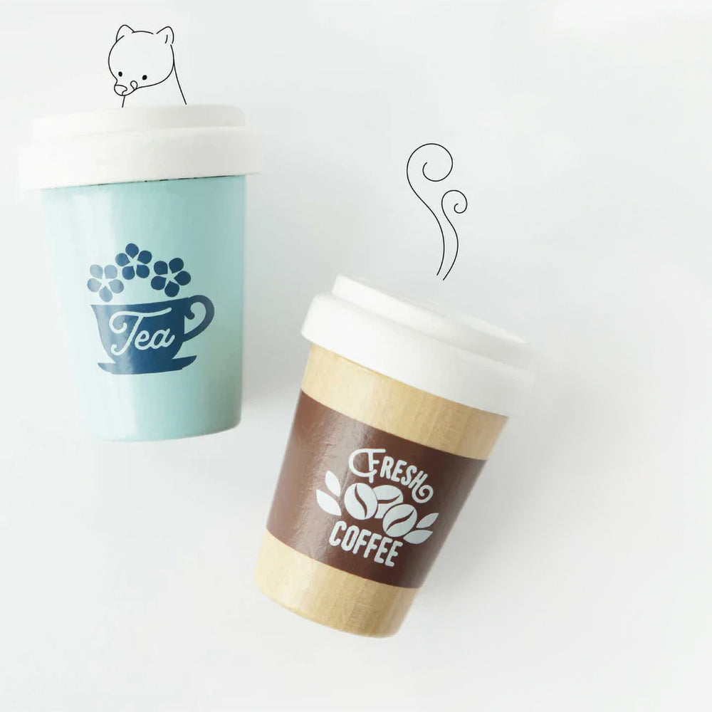Drewniane kubki na wynos: niebieski z napisem „Tea” i beżowy „Fresh Coffee”, tworzące zestaw do zabawy w kawiarnię. Wysokiej jakości drewniane napoje dla dzieci do kreatywnego odgrywania ról.