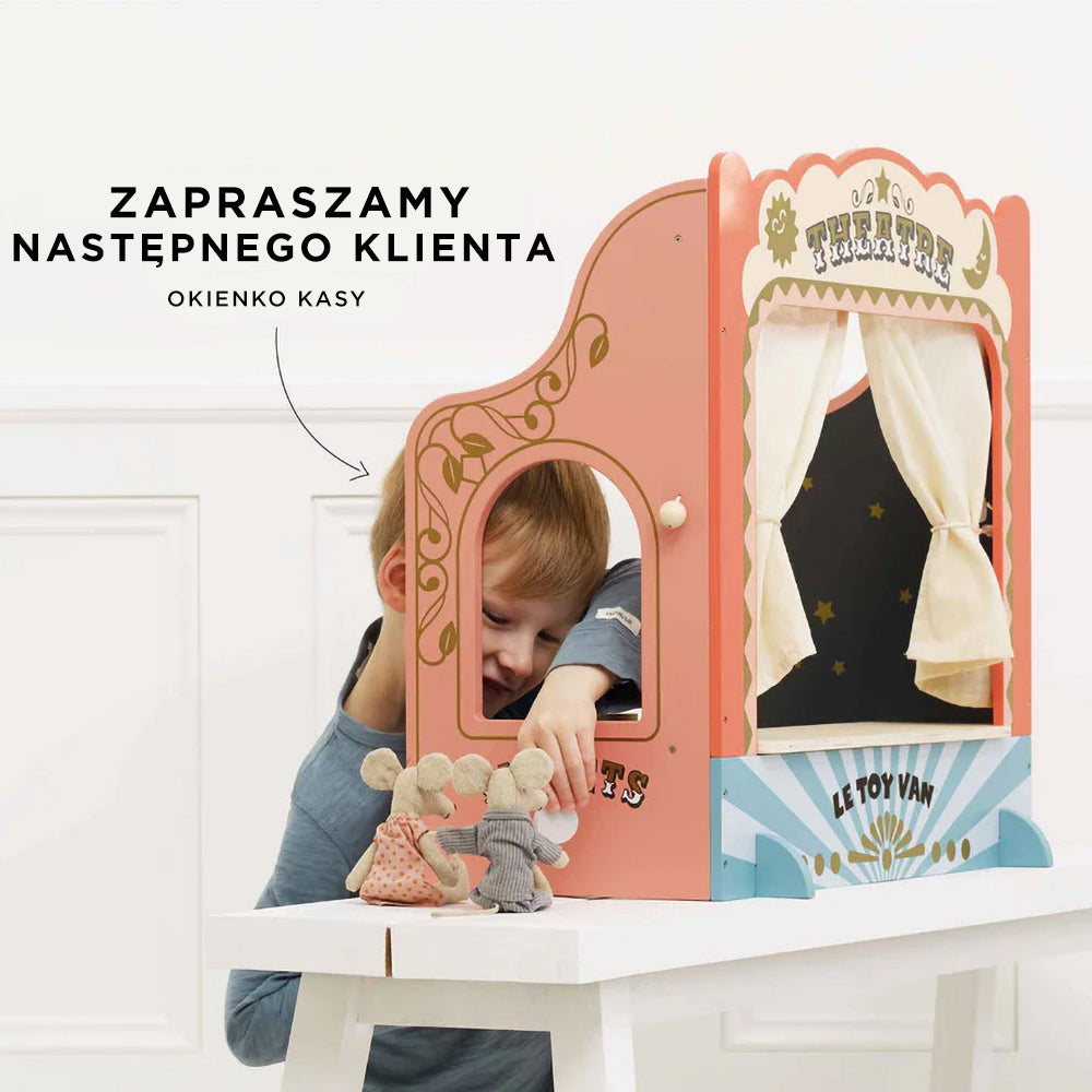 Chłopiec z radością bawi się drewnianym teatrzykiem dla pacynek i lalek, obsługując okienko kasowe. Ta urocza, pastelowa zabawka z bawełnianymi kurtynami i gwiezdnym wnętrzem doskonale stymuluje wyobraźnię dzieci do kreatywnego odgrywania ról.