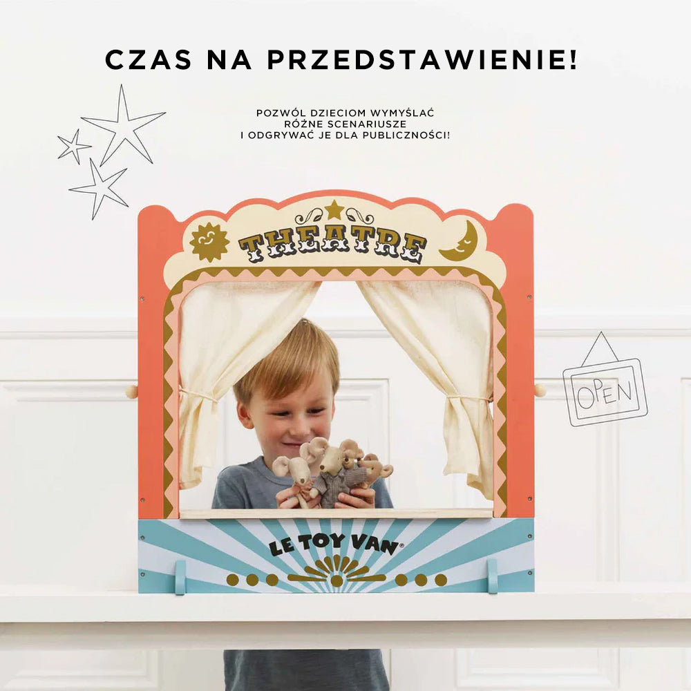 Uśmiechnięty chłopiec bawi się pacynkami w drewnianym teatrzyku Le Toy Van o pastelowych kolorach, idealnym do odgrywania ról.
